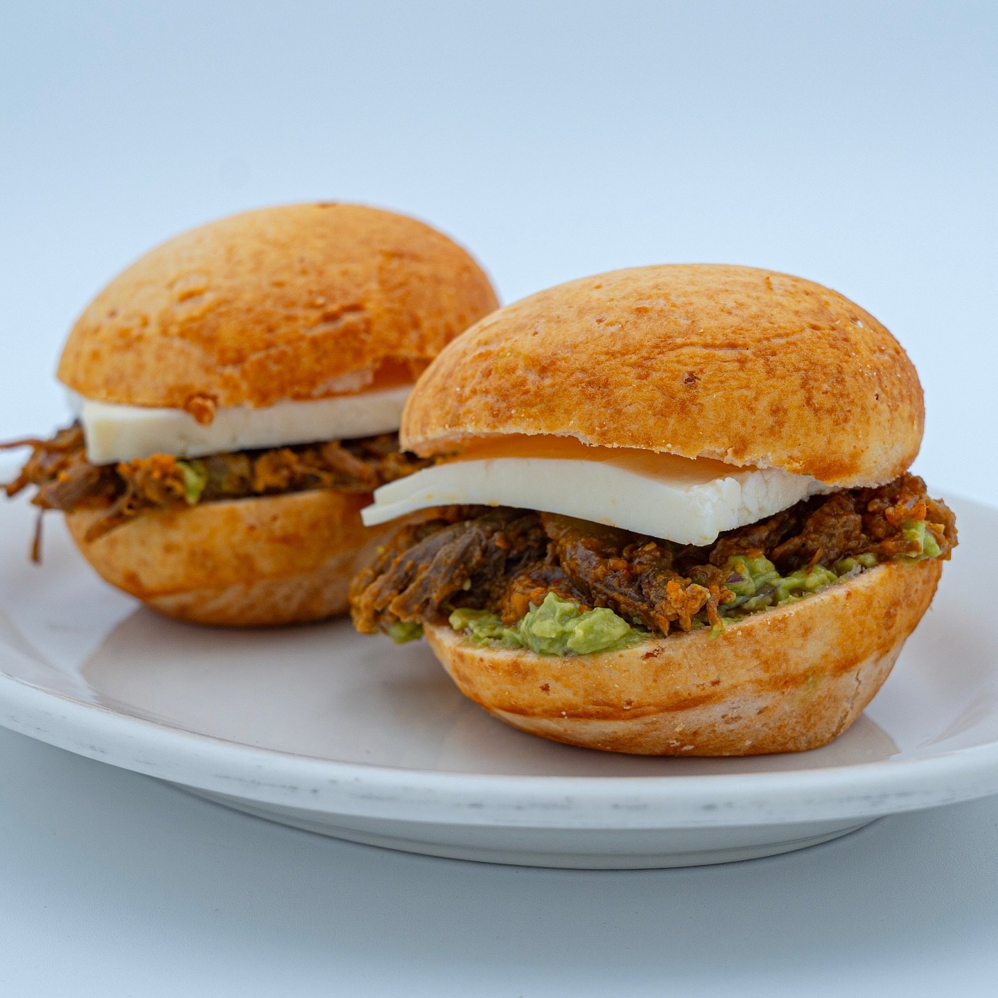 Pandebono slider with shredded beef, guacamole and queso